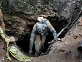 Illegal miners emerging from a mining shaft.